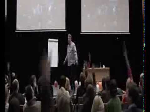 Algirdas Karalius facing the audience during a live seminar